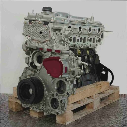 Motor 4JK1-TC auf Holzpalette vor weißem Hintergrund. Der metallische Motor ist leicht schräg dargestellt.
