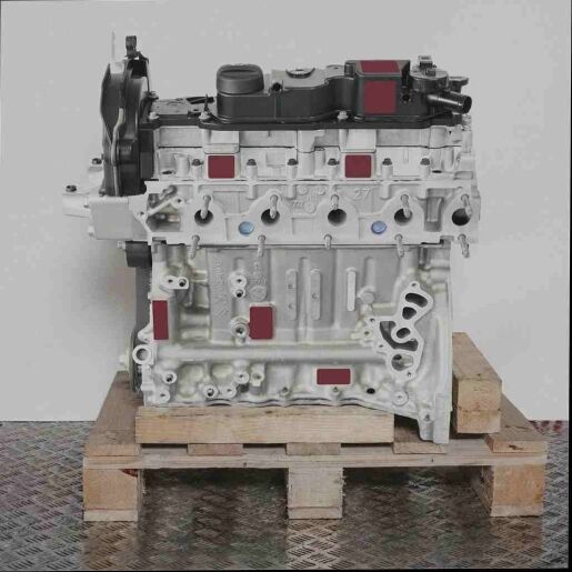 Silberner Motor 9HW (DV6BTED4) auf Holz-Palette vor weißem Hintergrund. Frontale Seitenansicht des Motors ohne Logos.