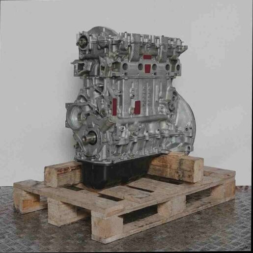 Kompletter Motor 9HX auf Holzpalette vor weißem Hintergrund. Der Motor besteht hauptsächlich aus silbernen Metallteilen und einer schwarzen Ölwanne.