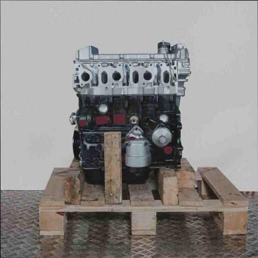 Motor AAA auf Holzpalette vor weißem Hintergrund. Der Motor, vertikal ausgerichtet, zeigt silberne und schwarze Komponenten.