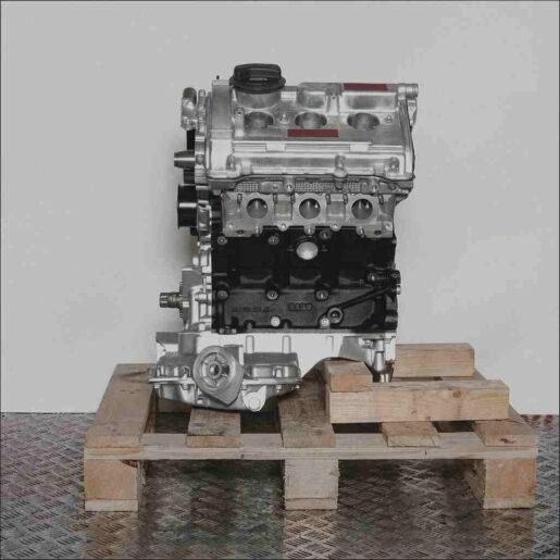 Motor ALG auf Holzpalette vor weißem Hintergrund. Der silber-schwarze Motor ist vertikal ausgerichtet.
