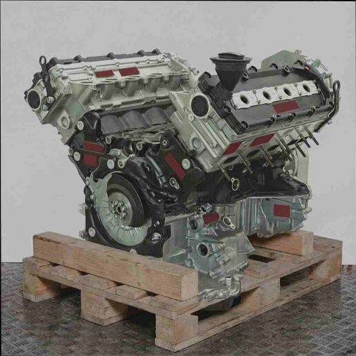 Schwarzer und silberner CTEC V-Motor auf Holzpalette vor weißem Hintergrund. Seitenansicht des Motors, leicht von oben aufgenommen.