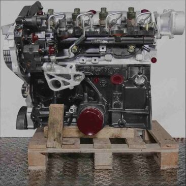 Seitenansicht eines Motors F9Q 800 auf einer Holzpalette vor weißem Hintergrund. Der Motor mit schwarzen, grauen und gelben Komponenten ist vertikal ausgerichtet.