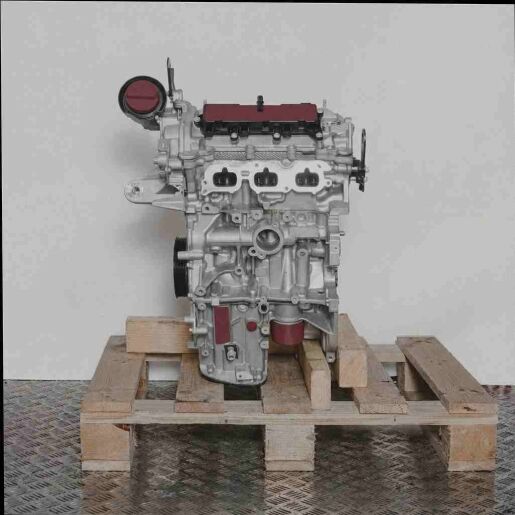 Silberner Motor H4DA401 mit schwarzen und gelben Akzenten auf einer Holzpalette vor weißem Hintergrund. Der Motor ist seitlich abgebildet und zeigt einen gelben Deckel.