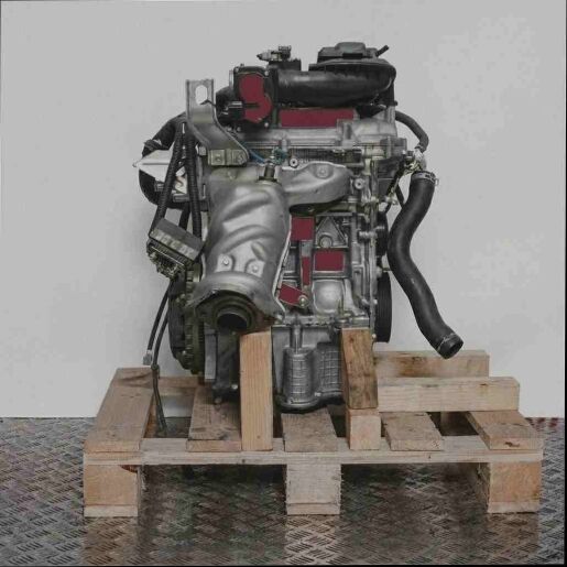 HR12DDR Motor auf Holzpalette vor weißem Hintergrund. Seitenansicht des kompletten Motors, ideal für Ersatzteile und Reparaturen.