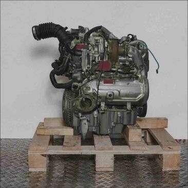 Seitenansicht eines Motors K9K 658 auf einer Holzpalette vor weißem Hintergrund. Der Motor ist vollständig sichtbar und vertikal ausgerichtet.