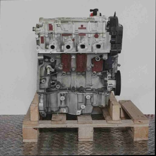 K9K 877 Motor auf Holzpalette vor weißem Hintergrund. Der graue und schwarze Motor ist freigestellt und vertikal dargestellt.