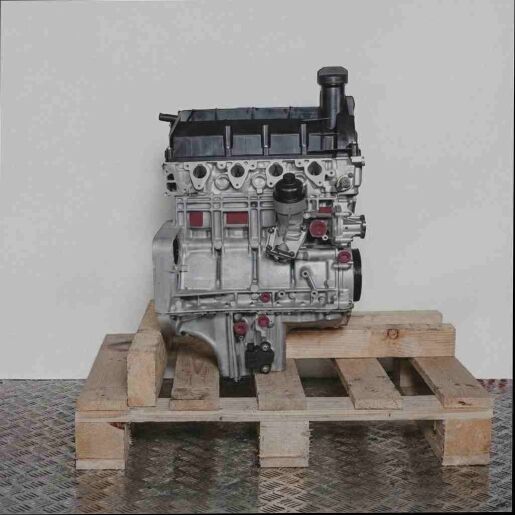Motor M 166.940 auf Holz-Palette vor weißem Hintergrund. Der silberne Motor mit schwarzen Kunststoffteilen ist seitlich abgebildet.