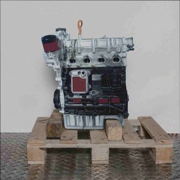CAVC Motor auf Holzpalette vor weißem Hintergrund. Der silberne Motorblock kontrastiert mit dem schwarzen Unterteil. Perfekt für Ersatzteile.