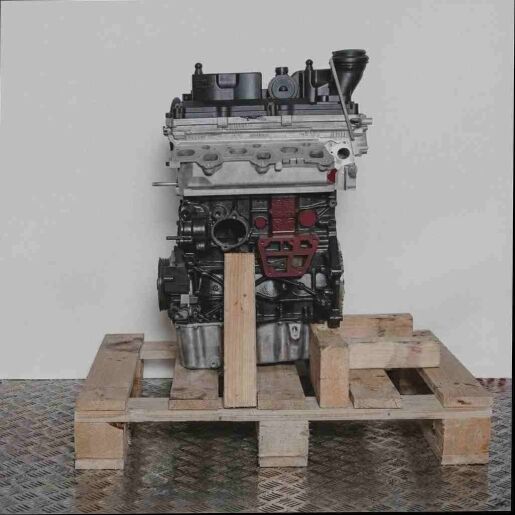 Motor CFWA auf Holzpalette vor weißem Hintergrund. Der grau-schwarze Motor ist seitlich betrachtet.